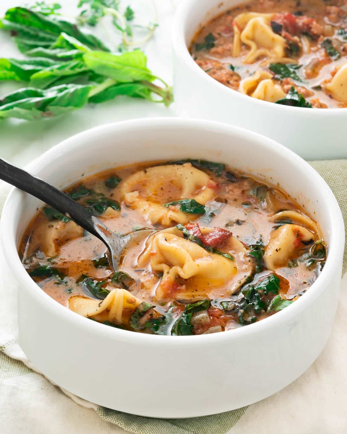 a bowl of creamy tortellini soup with sausage